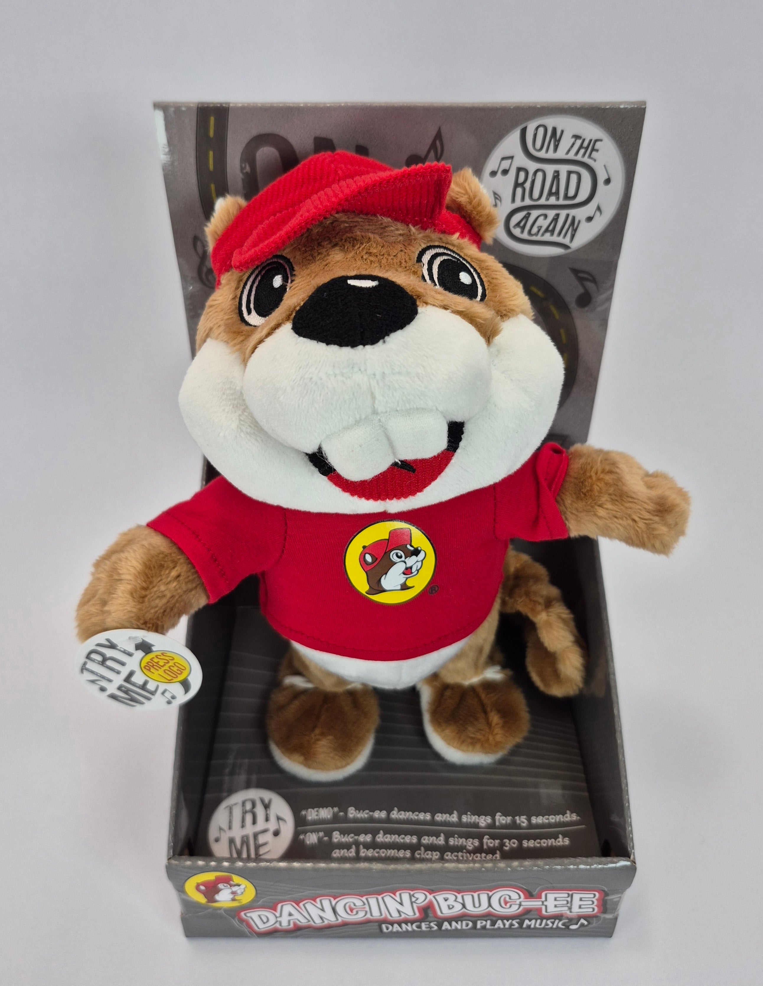 Plush toy resembling a beaver in a red outfit with packaging on a white background