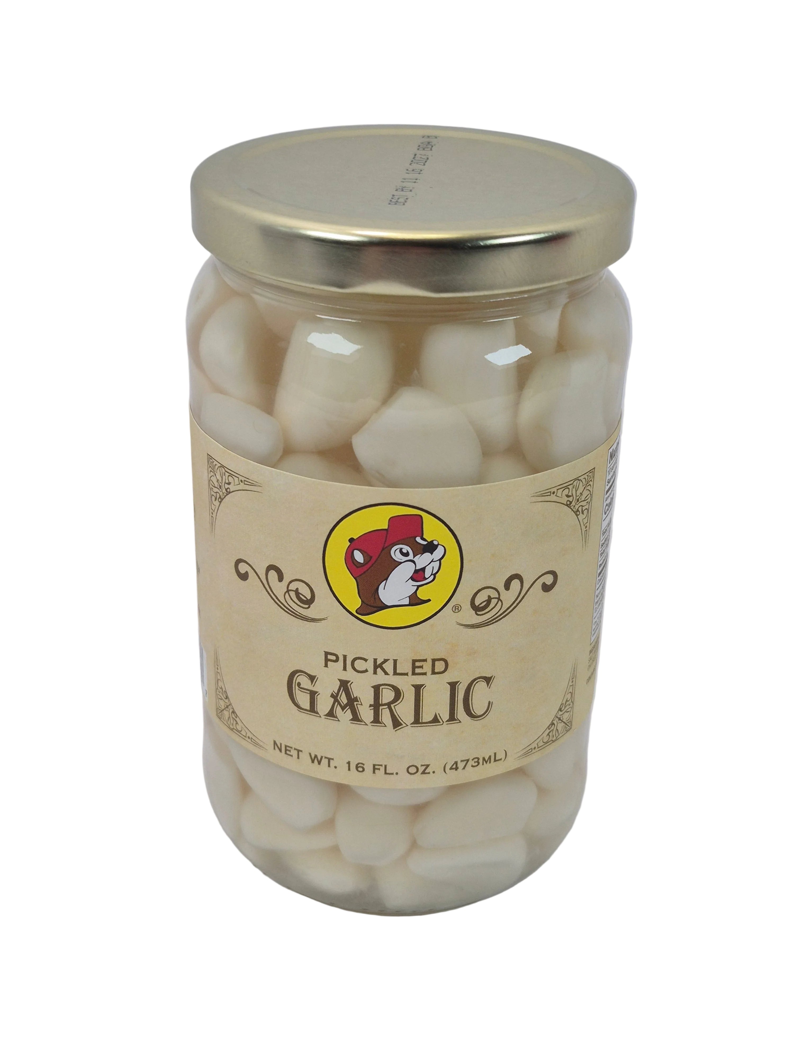 Jar of pickled garlic with a gold lid on a white background