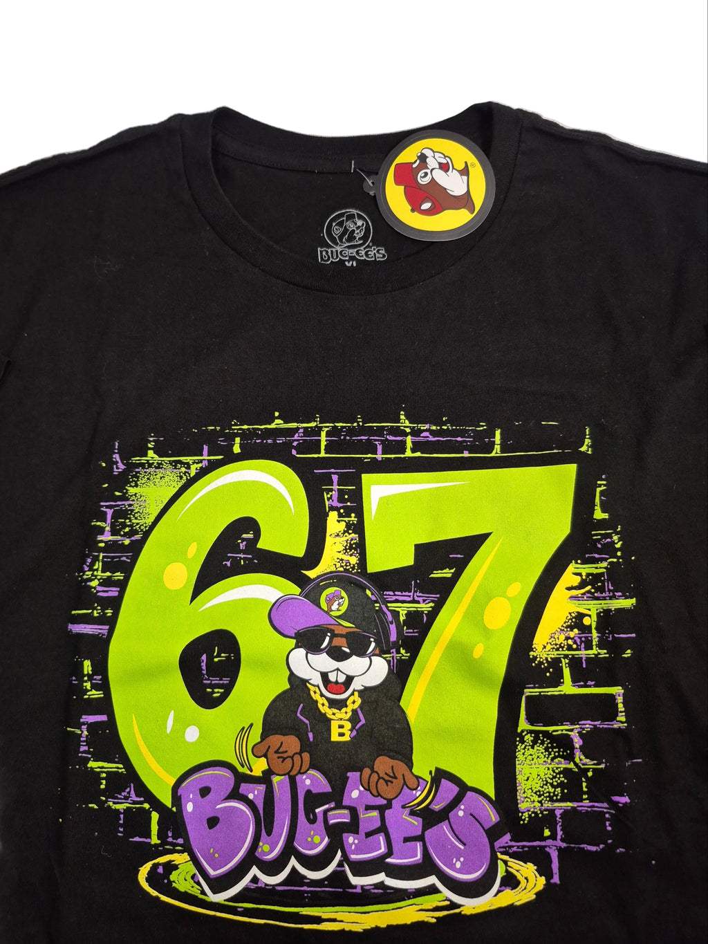 Black t-shirt with a colorful graphic of a character and '67 Buc-ee's' text on a white background