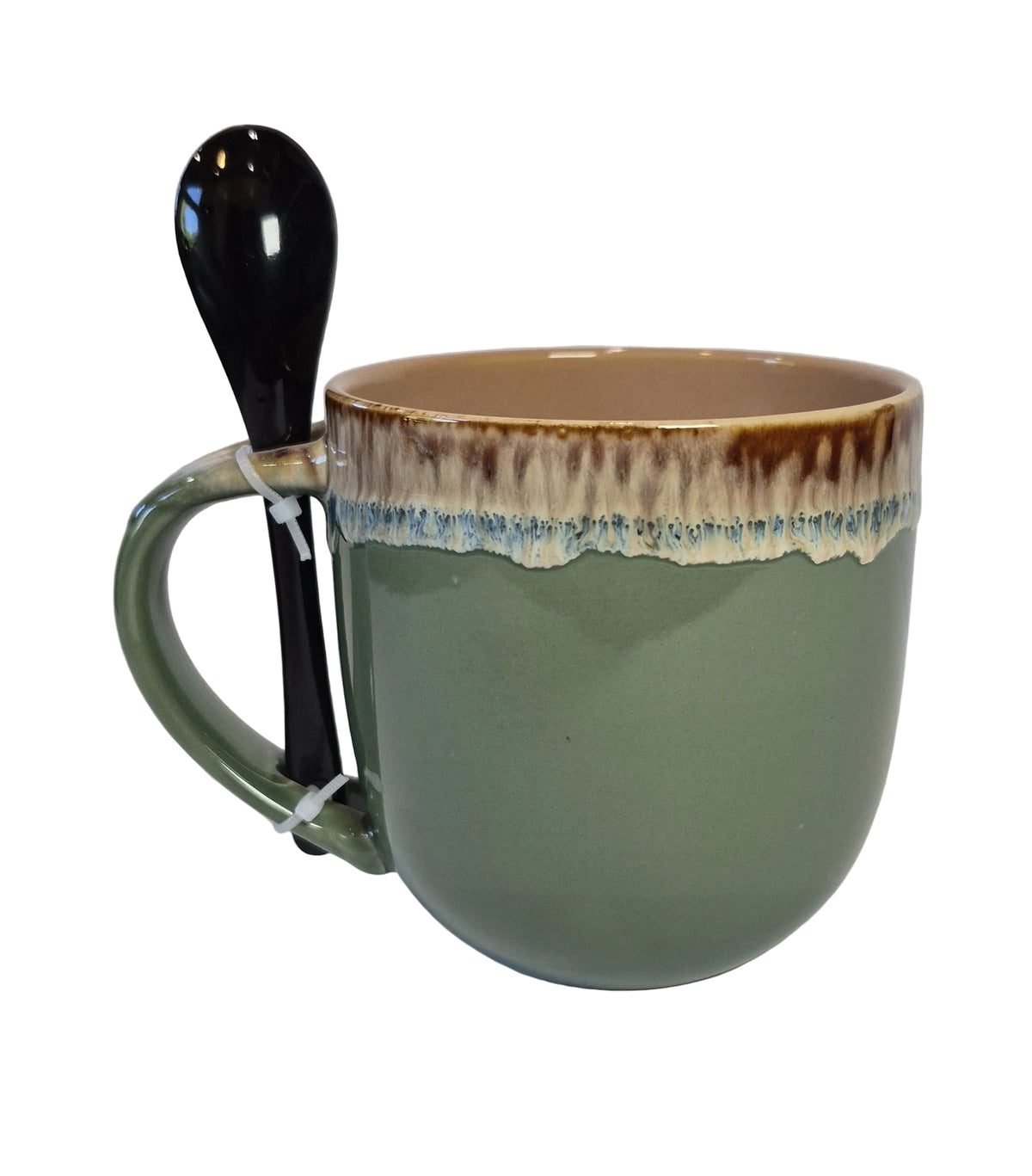 Green ceramic mug with brown rim and black spoon on a white background