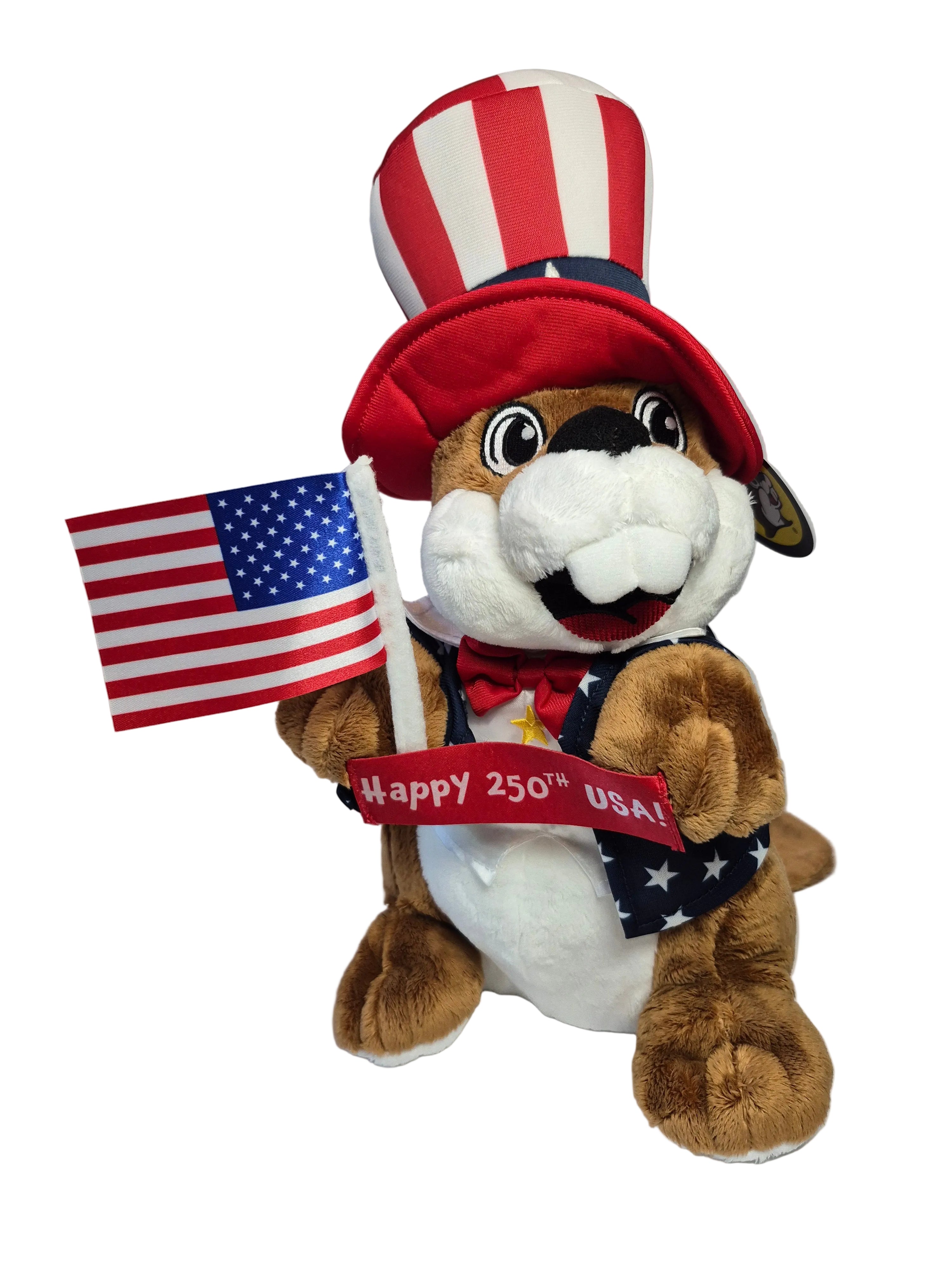 Plush dog toy with American flag and 'Happy 250th USA!' sign, wearing an Uncle Sam hat.