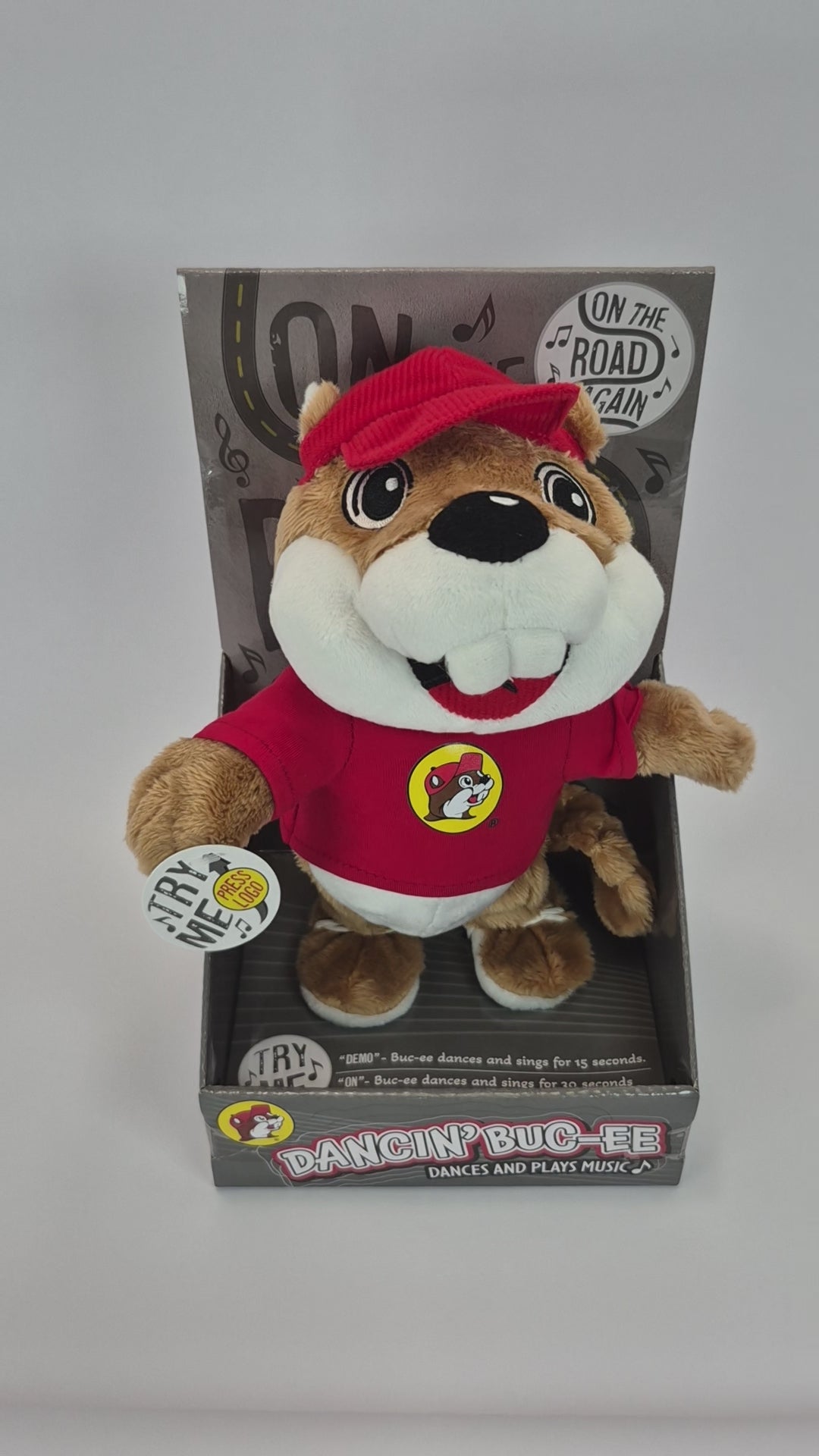 Plush toy resembling a beaver in a red outfit with packaging on a white background